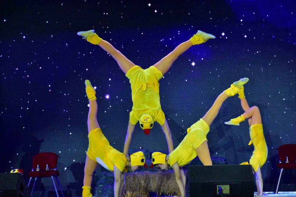A group of people in yellow clothing on a stage

Description automatically generated with low confidence