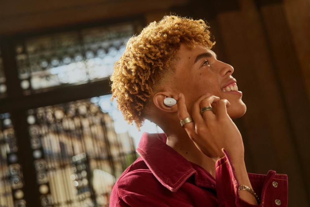 A person with curly hair wearing wireless earbuds

Des<i></i>cription automatically generated